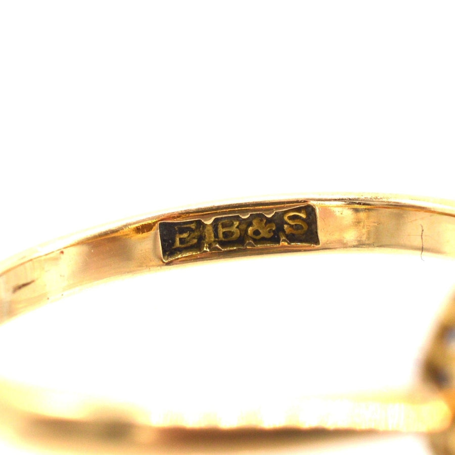 Close-up of the stamp on an Edwardian 18ct gold ruby and diamond cluster ring, featuring E.B.&S. stamp.