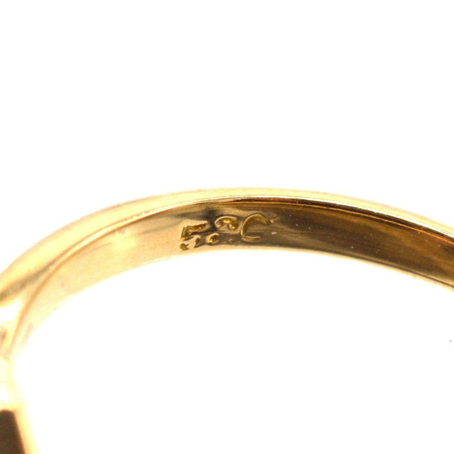 Close-up of the inner band of an Edwardian 18ct gold ring, showcasing its stamp details.