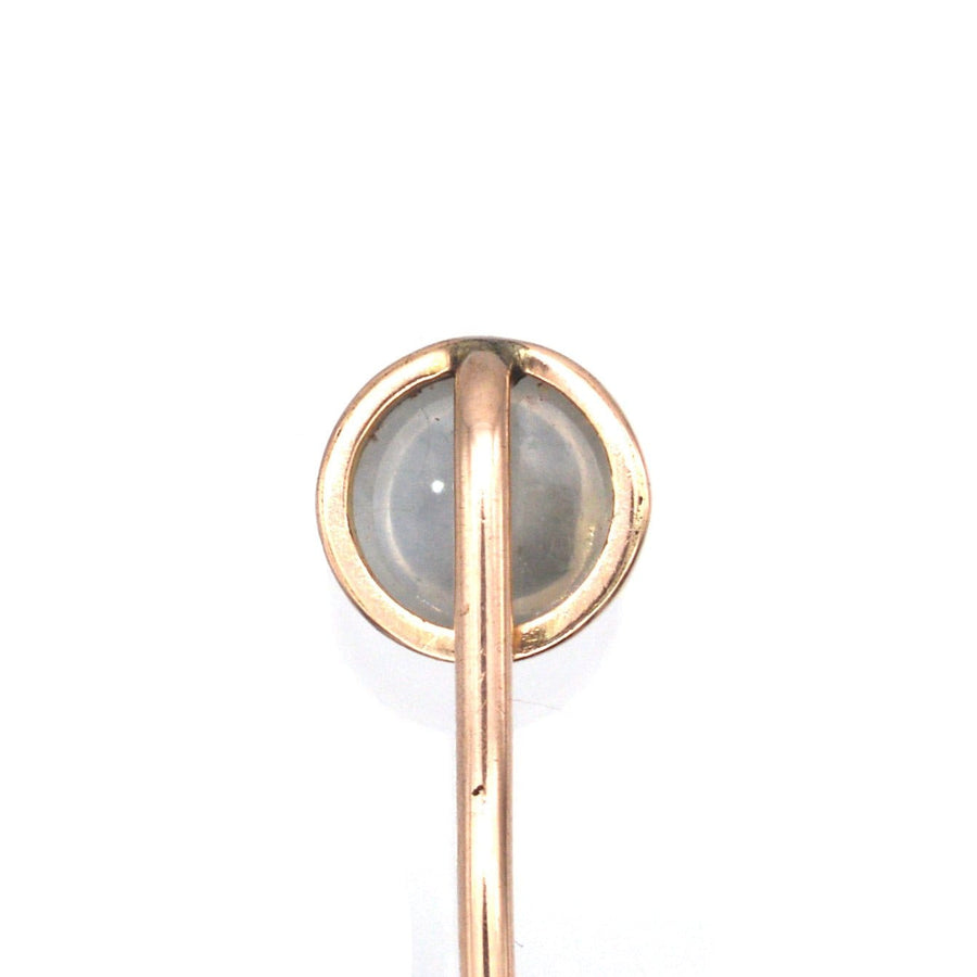 Close-up of an Edwardian 18ct gold tie pin featuring a luminous moonstone, highlighting its unique bluey gray glow.