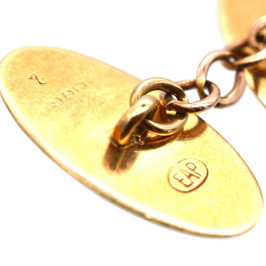 Close-up of Edwardian 9ct gold cufflinks showcasing foliage design and stamp detail, elegant vintage jewelry.