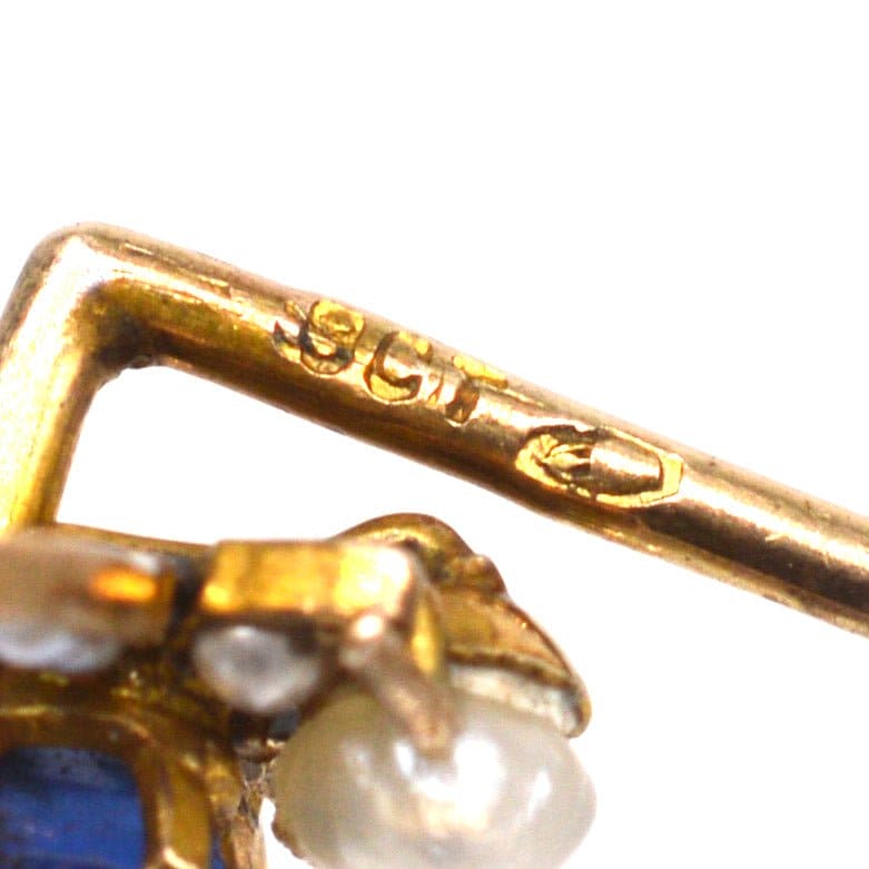 Close-up of a stamp on an Edwardian 9ct gold sapphire and natural pearl bee tie pin.