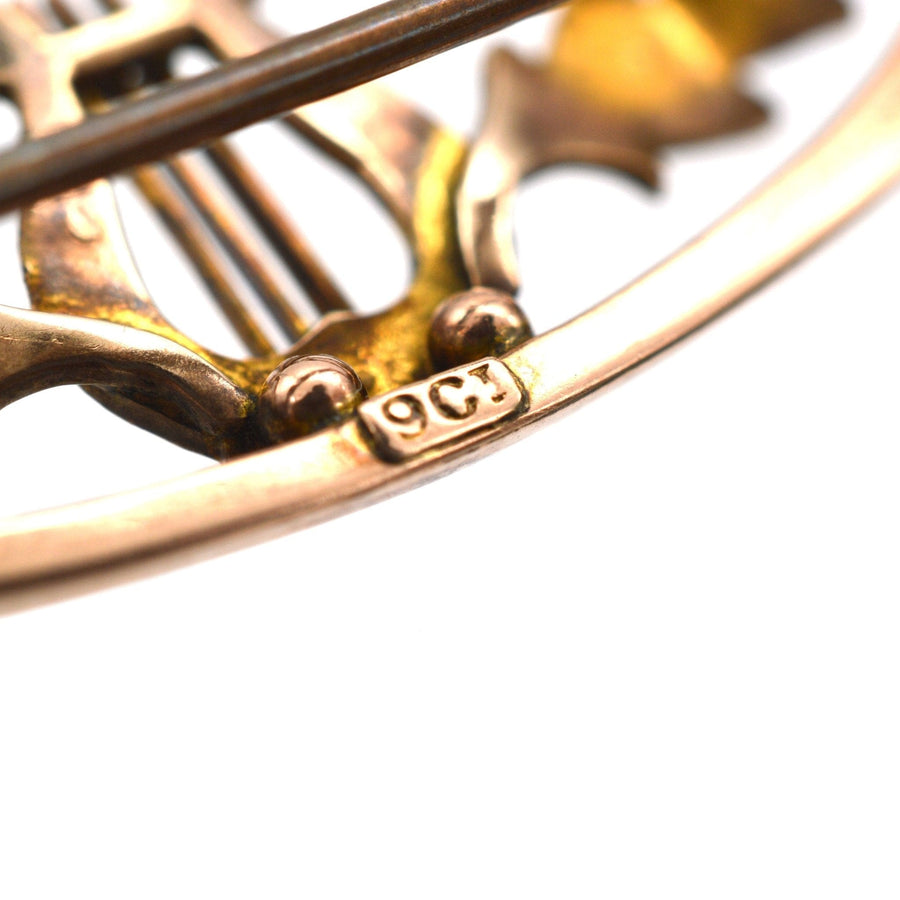 Close-up of 9ct gold antique lyre bar brooch showing stamp and intricate scroll details.