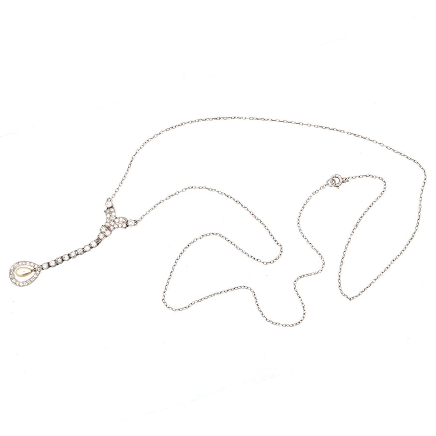 Edwardian platinum pendant with diamond and natural pearl on articulated chain, displayed elegantly.