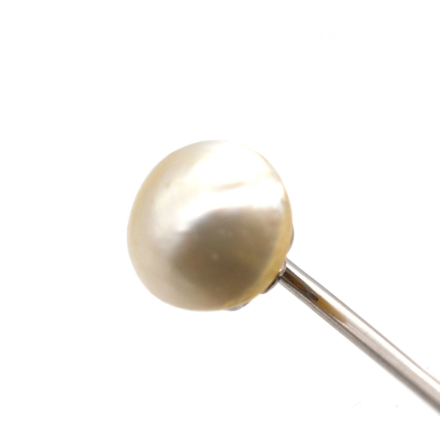 Close-up of an Edwardian platinum tie pin featuring a large natural pearl, circa 1910-1920s, perfect for enhancing silk ties.