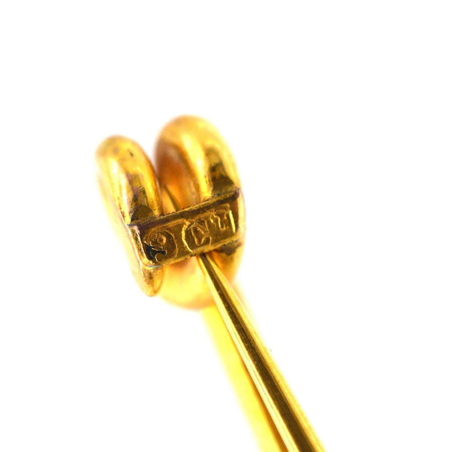 Close-up of a large Victorian 9ct gold stock pin brooch, showing intricate details and stamp.