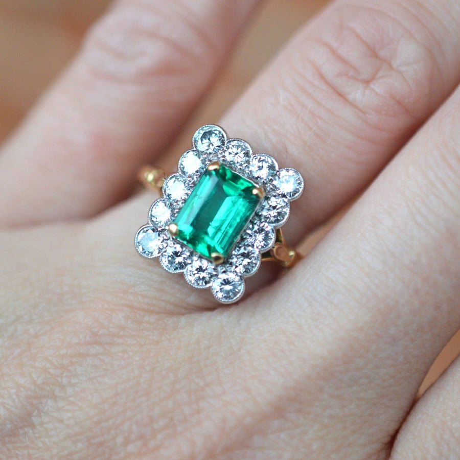 Large vintage 18ct gold and platinum ring featuring a 1.70ct emerald surrounded by 14 diamonds, perfect for engagement or cocktail.