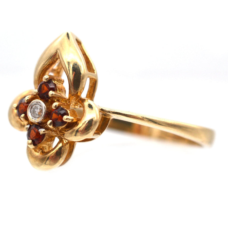 Late 20th century 18ct gold ring featuring hessonite garnets and a diamond, styled as a floral design.