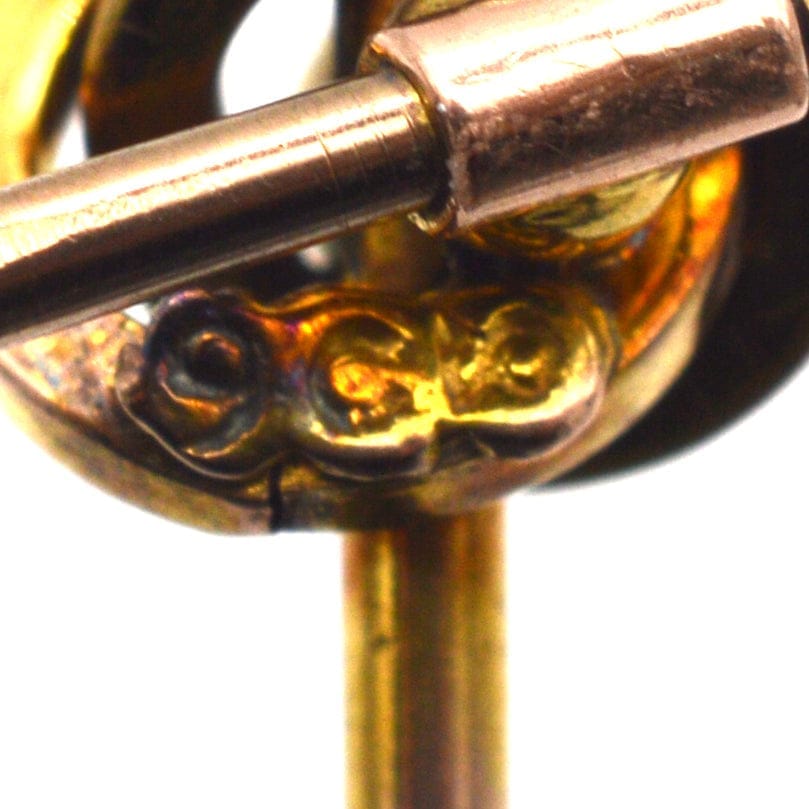 Close-up of 9ct gold stamp on a Victorian knot tie pin with intricate design.