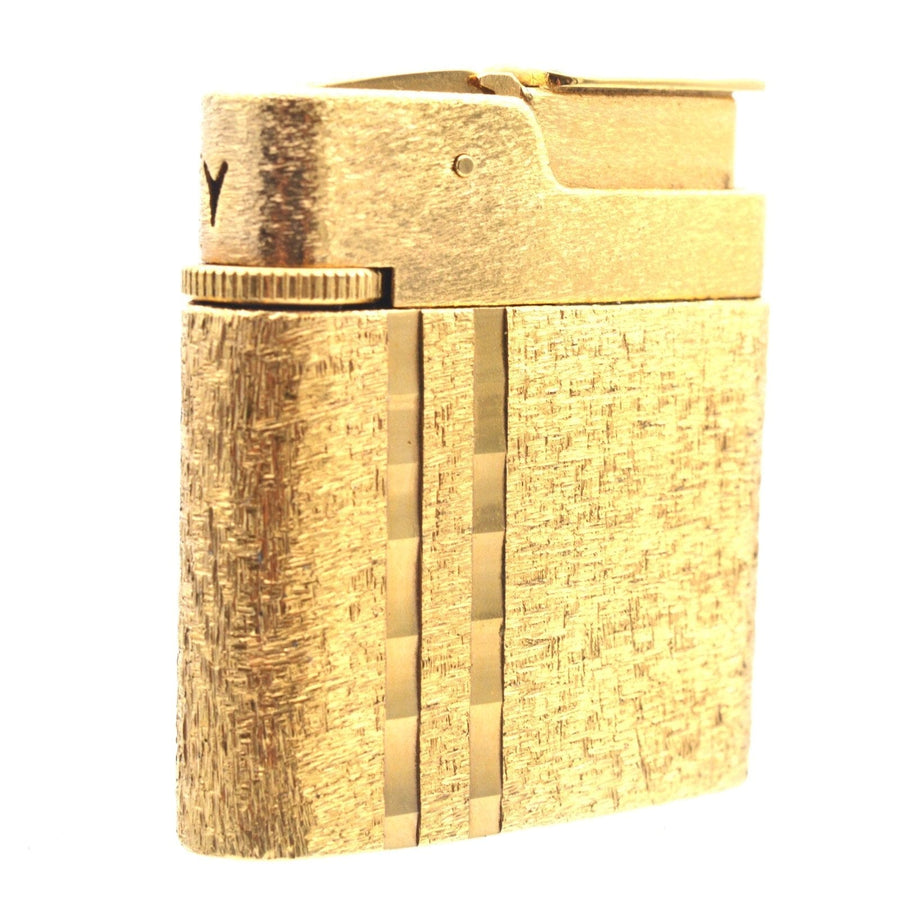 Vintage Norman Hartnell gold lighter with textured finish, part of a mid-century jewelry set.