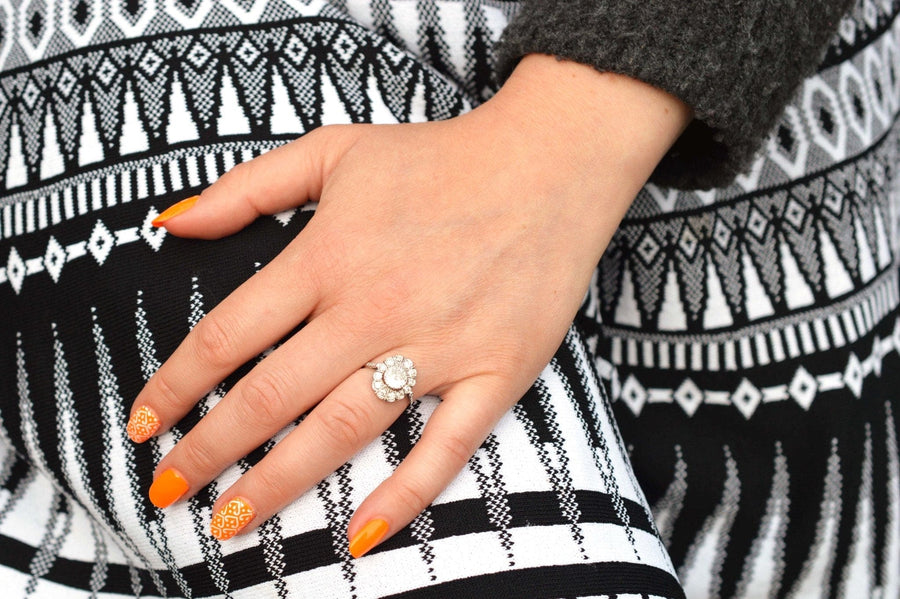 Mid Century 18ct white gold oval diamond cluster ring showcased on a hand with vibrant orange nails.