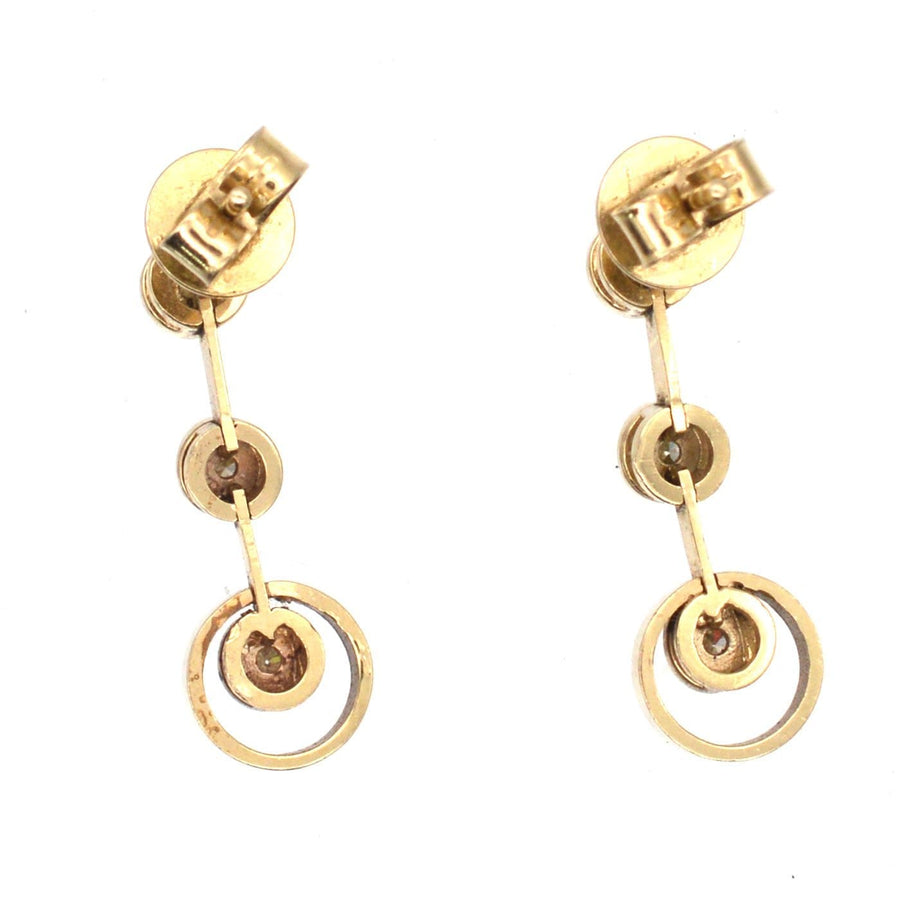 Modern 18ct gold three stone diamond drop earrings with bright white diamonds, perfect for weddings and formal events.