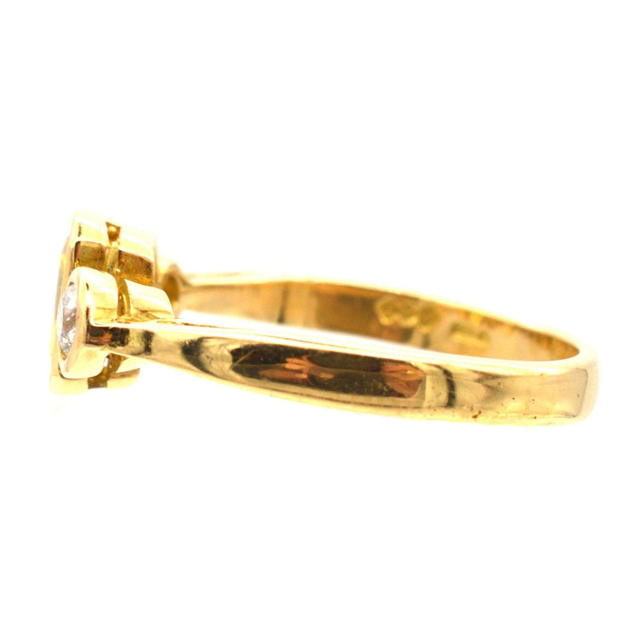 Modern 18ct gold ring featuring a yellow sapphire and two diamonds, showcasing stylish elegance.