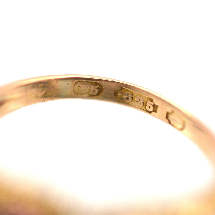 Close-up of the stamp on a gold ring indicating purity and craftsmanship details.