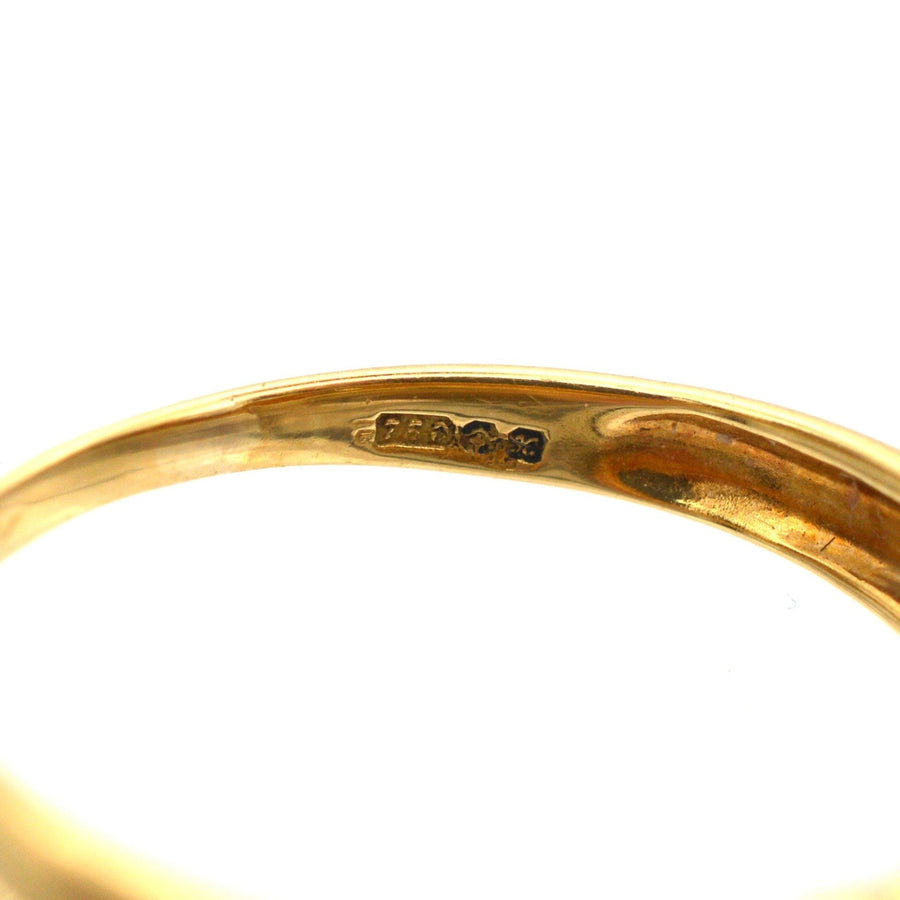 Close-up of the interior stamp of a vintage 18ct gold ring, showcasing the detailed craftsmanship.