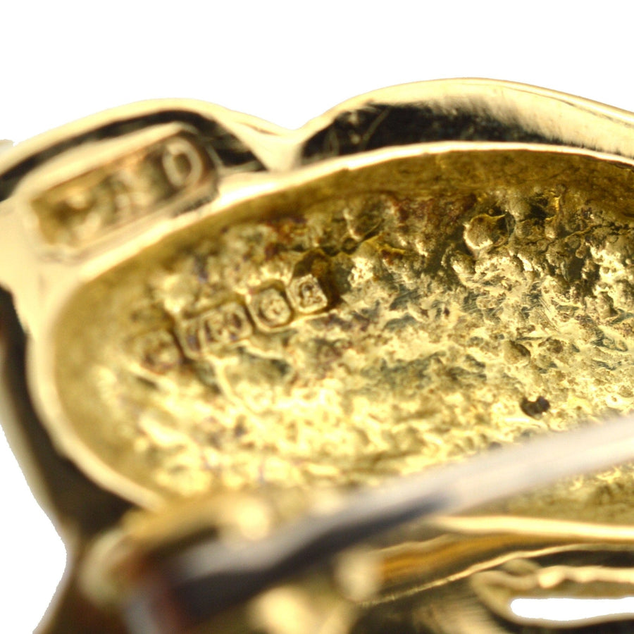 Close-up of the back of a vintage 18ct gold running rabbit brooch with detailed stamp.