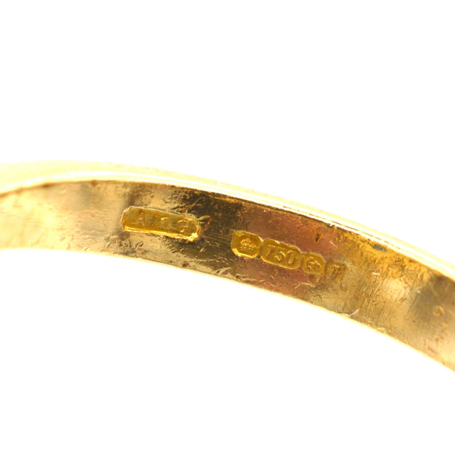 Close-up of the stamp on 18ct gold ring, showcasing metal purity and origin details.