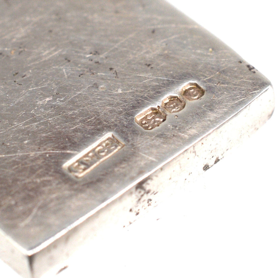 Close-up of vintage 1970s silver domino pendant showing stamp details, made in London in 1977.