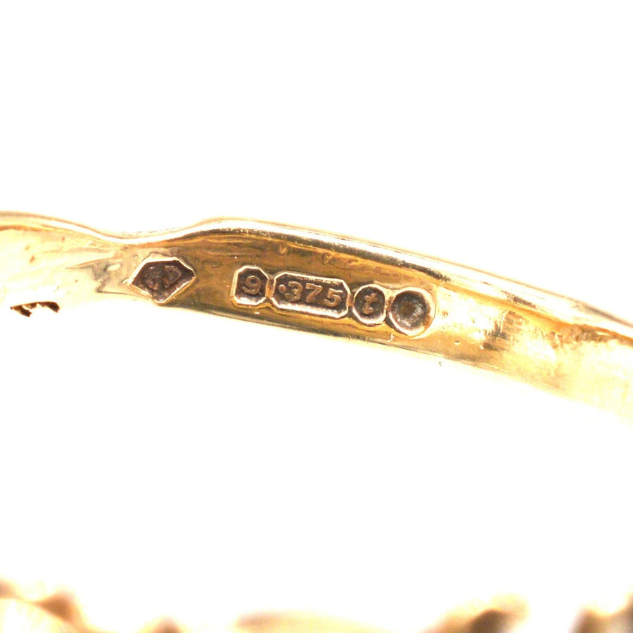Close-up of the stamp and purity stamp on a vintage 9ct gold acrostic ring from 1974.