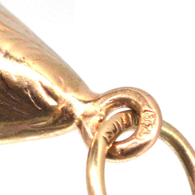 Close-up of a vintage 9ct gold mussel shell charm with stamp and attachment loop, ideal for charm bracelets or pendants.