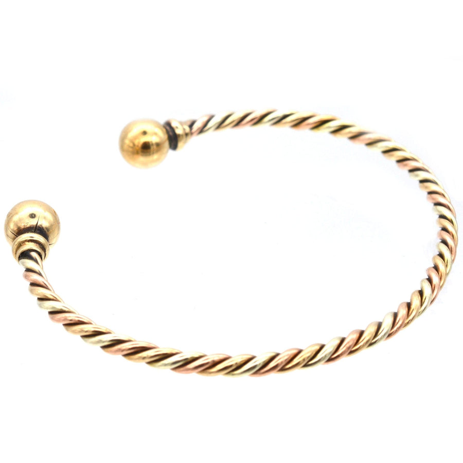 Vintage 9ct gold twisted three color gold open bangle with gold spheres on each end.