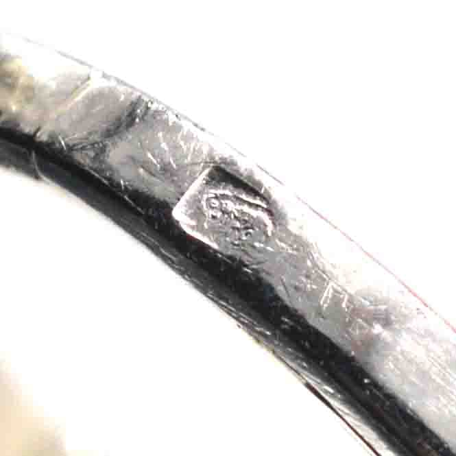 一枚复古铂金戒指上的印记特写，展示其真实性和工艺性。