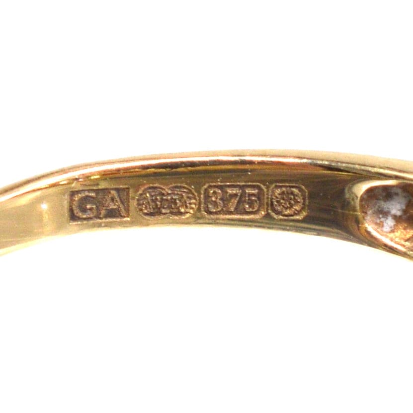 一枚古董 9ct 金戒指的印记，显示 GA 和 375 纯度标记，以确保其真实性。