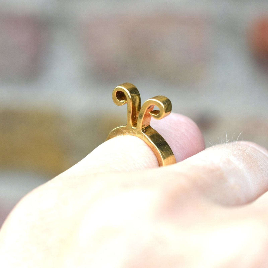 20 世纪 60 年代 Walter Schluep 设计的 18K 金白羊座戒指，佩戴在手指上，展现出复杂的设计和十二星座标志。