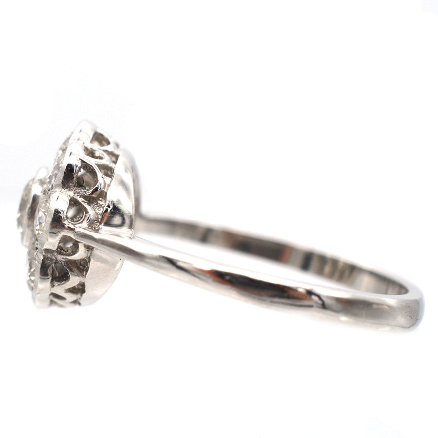 Art Deco platinum diamond cluster ring showcasing a sparkling design with intricate millegrain setting.