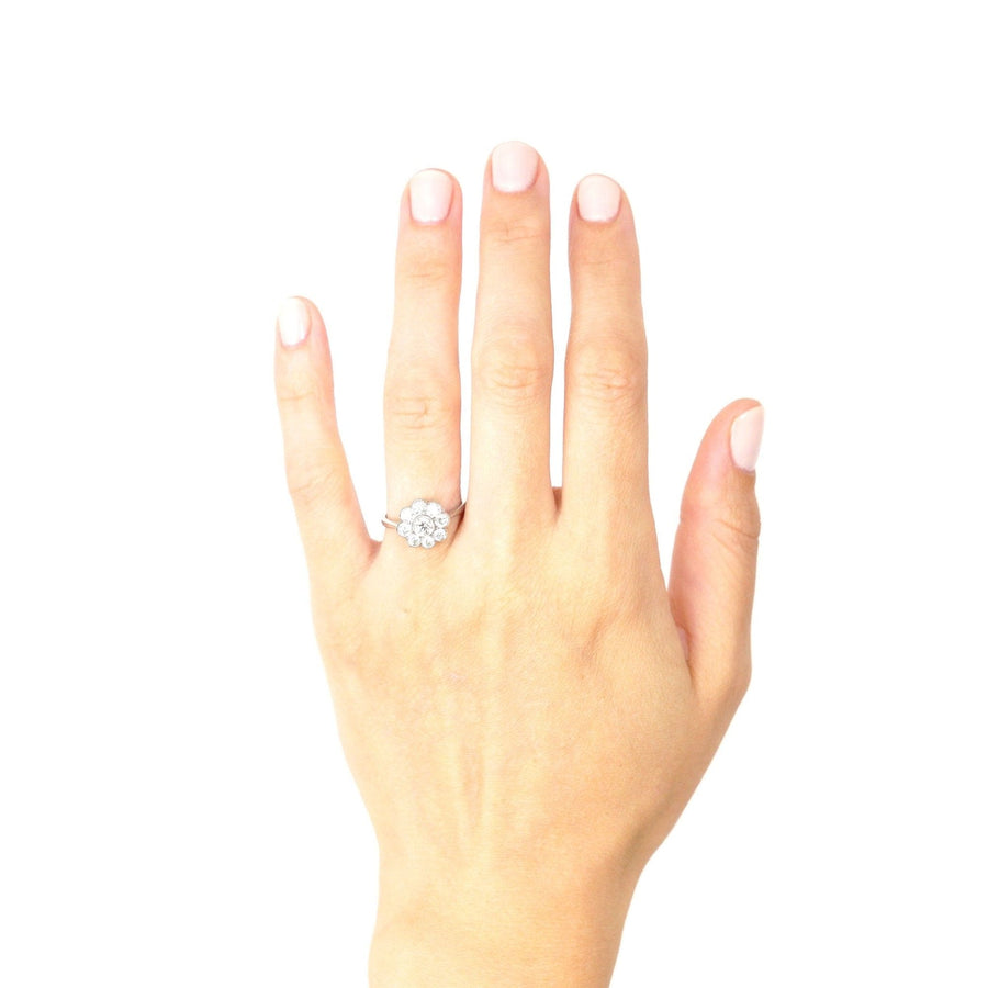 Beautiful hand wearing an Art Deco platinum diamond cluster engagement ring, showcasing its sparkle and elegance.