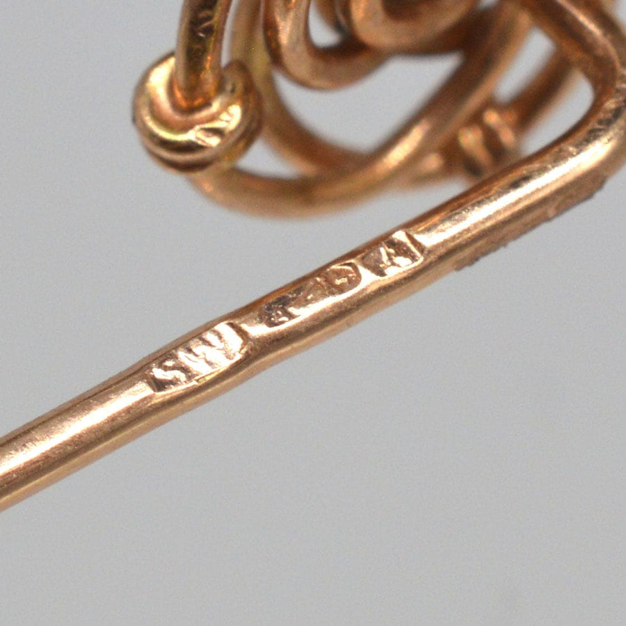 Close-up of hallmarks on an Austro-Hungarian 14ct gold tie pin, showcasing the intricate knot design.