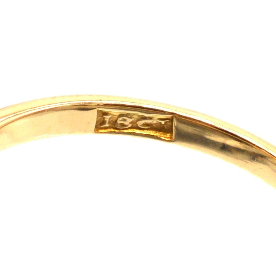 一枚复古交叉戒指内圈上显示 "18ct "的金质印记特写。