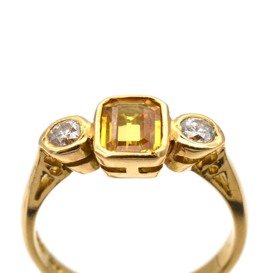 现代 18K 金戒指，中间镶嵌黄色蓝宝石和两颗白色钻石，是订婚的理想之选。