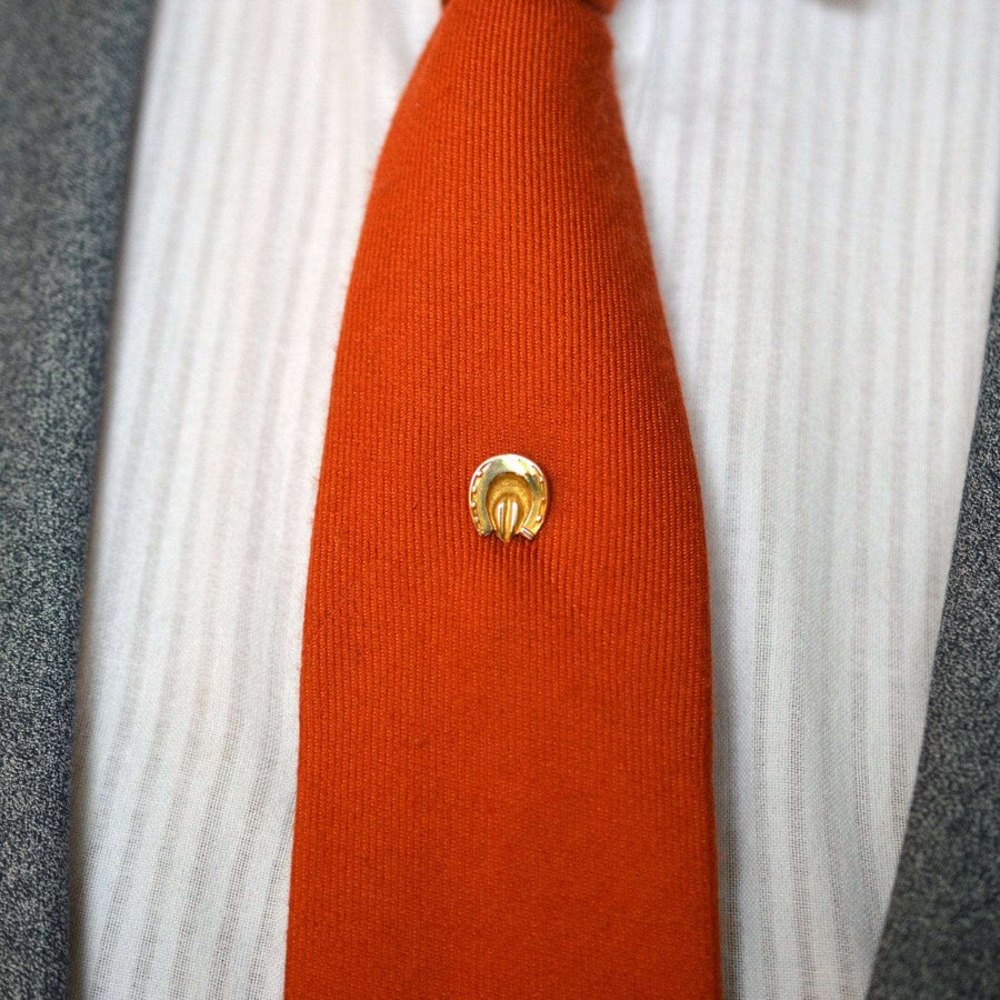 维多利亚时期的 9K 金马蹄形领带别针，配以鲜艳的橙色领带，象征着好运和保护。