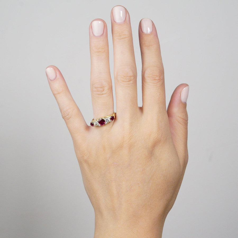 Victorian-style 1970s 18ct gold ring with ruby doublets and diamonds worn on a hand.